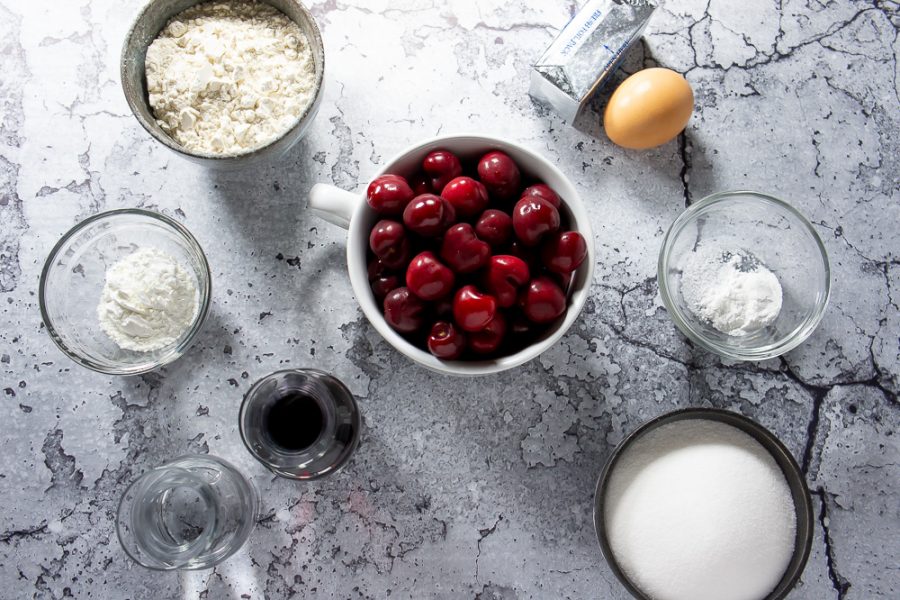 bowl of cherries, an egg, butter, flour, sugar, and red wine