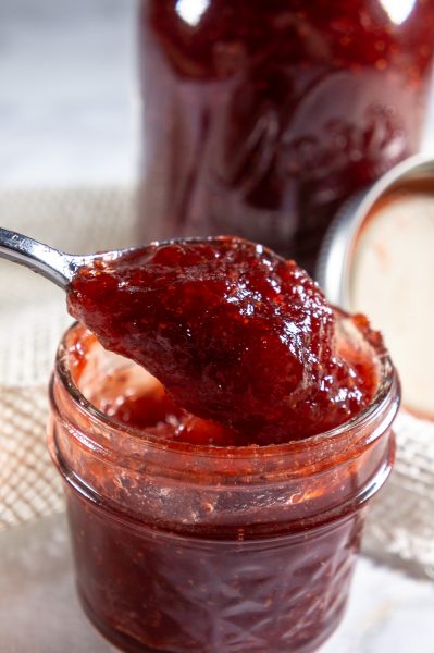 spooning strawberry jam from jar