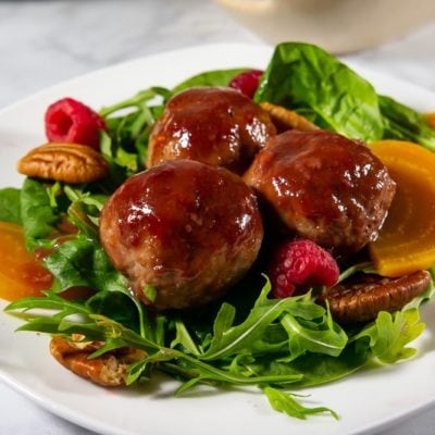 Green salad with golden beets and three glazed meatballs
