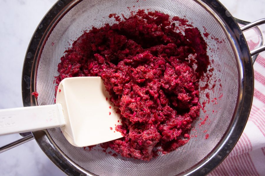 pomegranate pulp in a fine mesh sieve