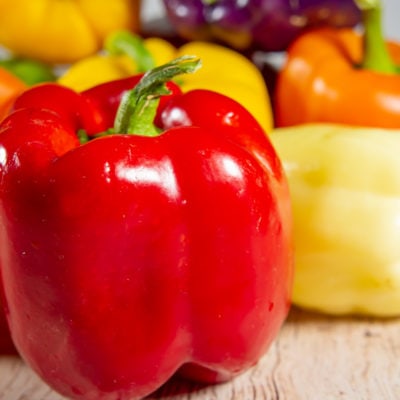a pile of bell peppers in various colors