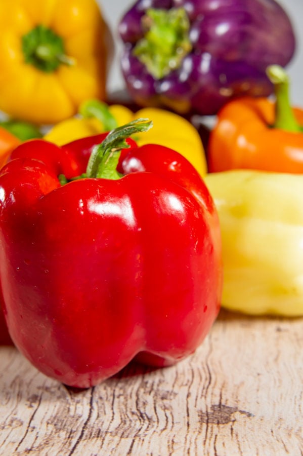 a pile of bell peppers in various colors