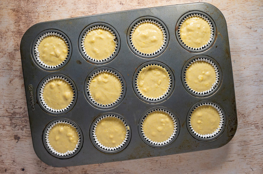 a muffin pan filled with cornbread batter