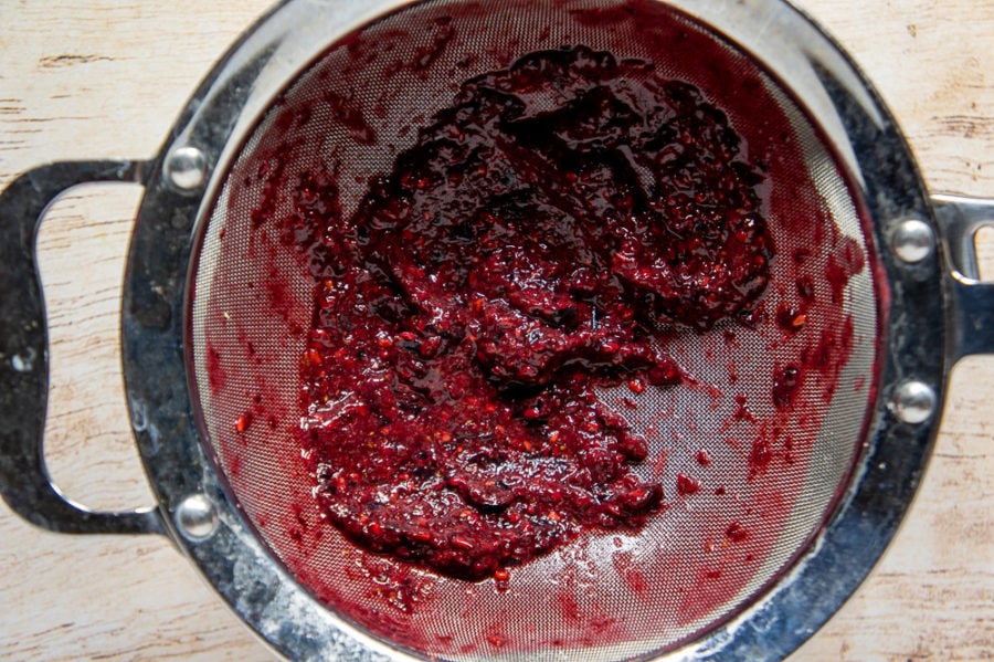 a strainer with blackberry pulp and seeds in it