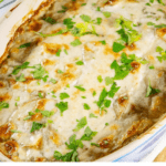 a casserole dish of layered potatoes baked in cream and topped with parsley