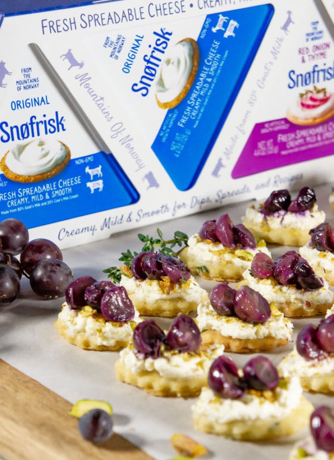 a serving board with goat cheese appetizers with roasted grapes in front of Snofrisk 3 pack