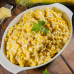 an oval white bowl full of homemade creamed corn.