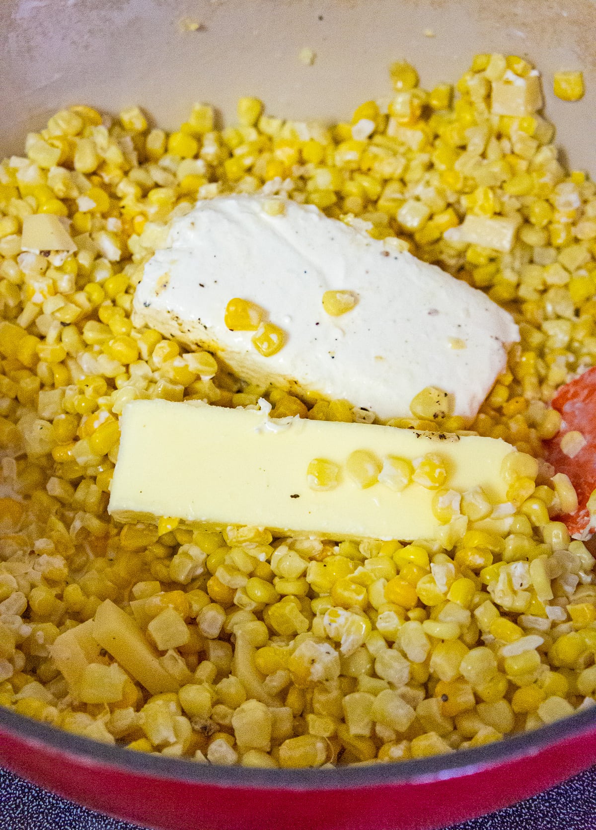corn kernels in a large pot with butter and cream cheese.