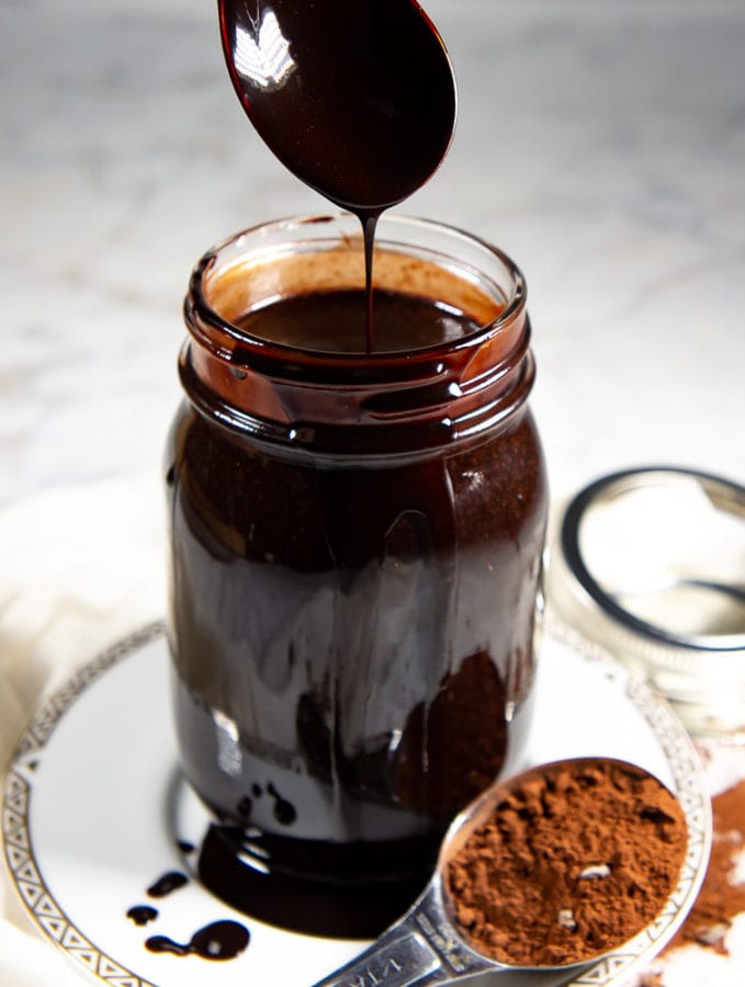 a jar of chocolate syrup on a plate