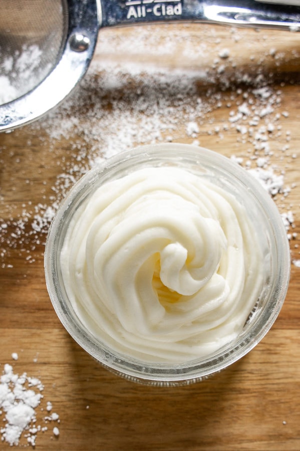 glass bowl of piped cream cheese frosting