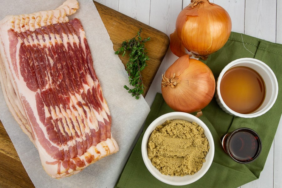 bacon with two onions, fresh thyme, beef stock, brown sugar, and maple syrup sitting beside it