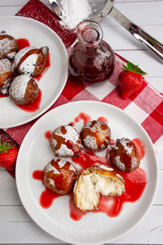 two plates of fried cheesecake bites on a red checked napkin