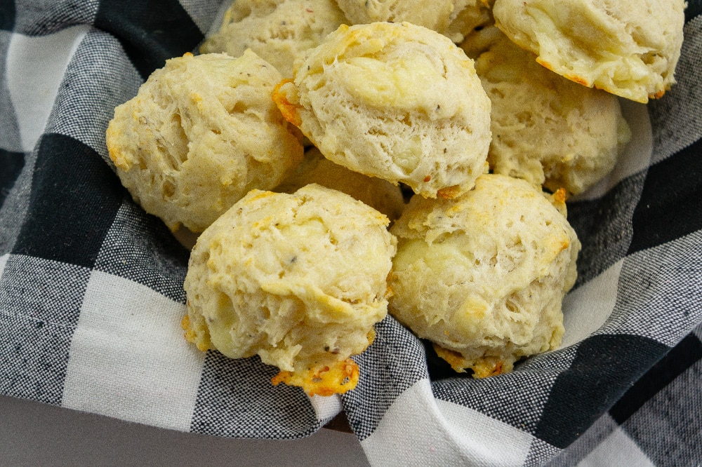 a black checkered napkin full of asiago biscuits