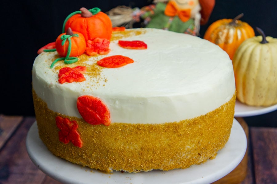a pumpkin layer cake with gold sprinkles and pumpkin decorations