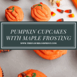 a white granite slab with pumpkin cupcakes over a single pumpkin cupcake on a plate