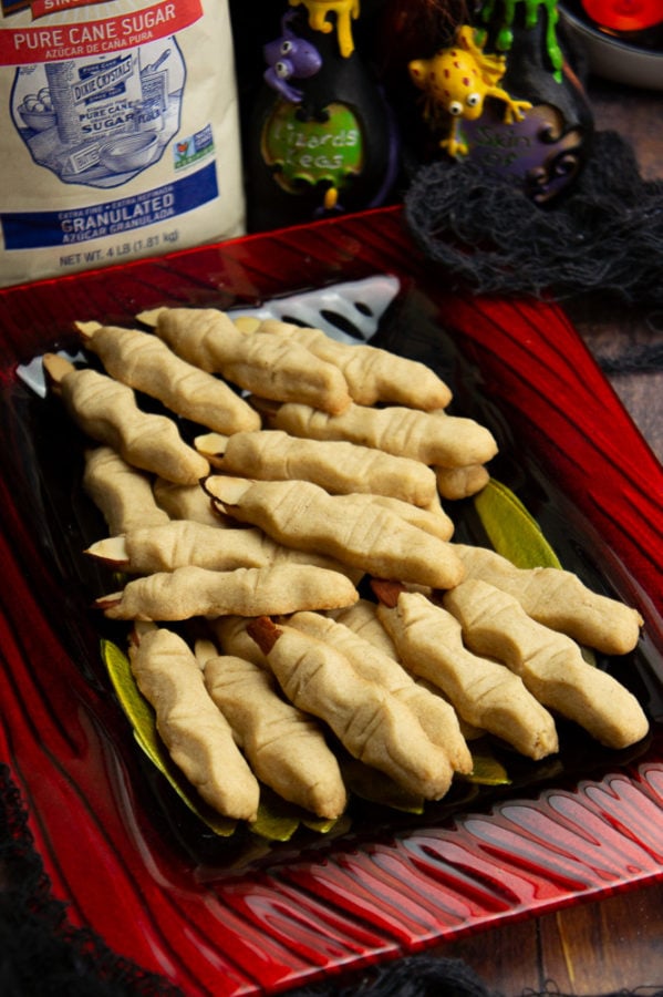 a plate of shortbread witches fingers and a bag of sugar