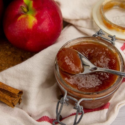 a small jar of apple butter with a spoon scooping some out