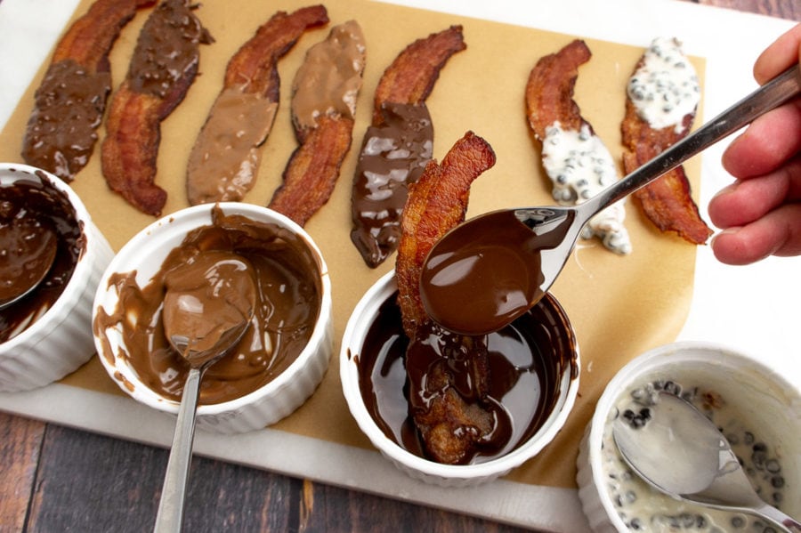 bacon slices laid out on a parchment paper coated with chocolate