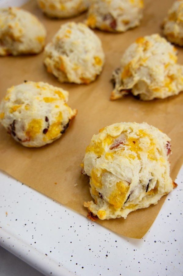 ham and cheddar biscuits baked on a baking sheet with parchment paper