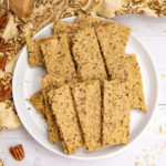 a plate of homemade granola nut bars on a white table with a printed yellow cloth