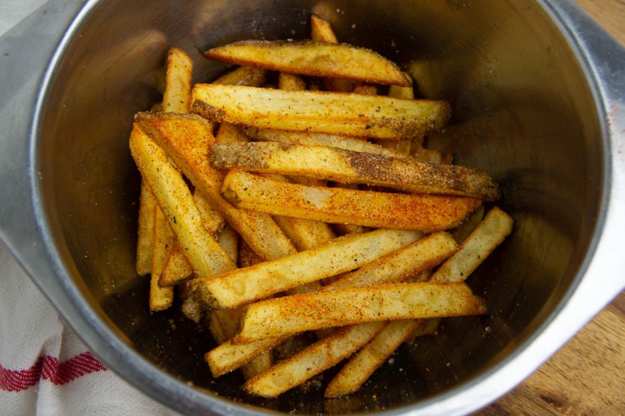 a bowl of fries tossed with cajun seasoning