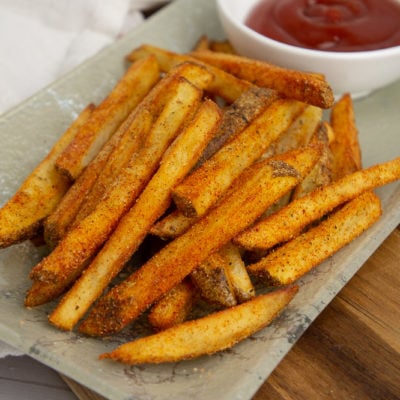 a plate of fried cajun fries with ketchup