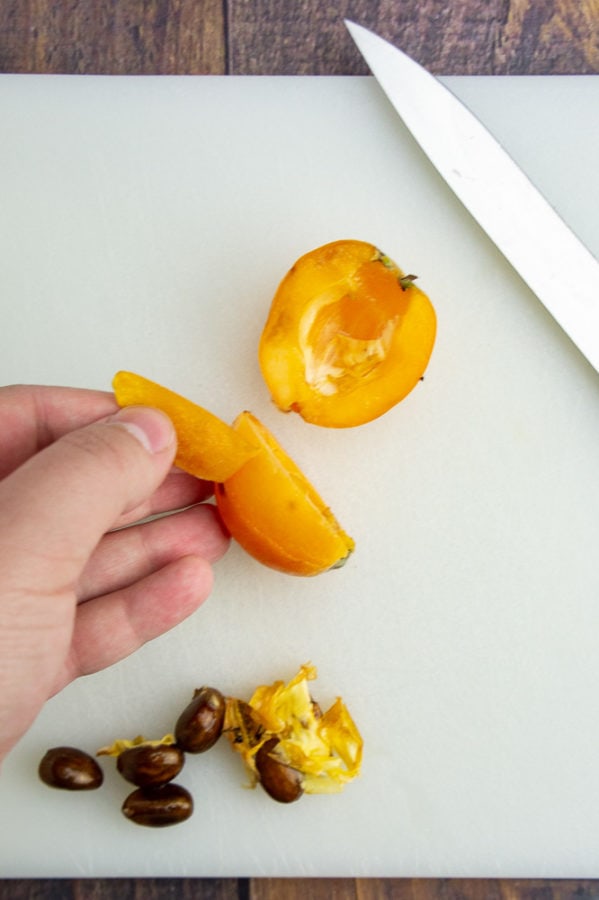 skin being peeled from a loquat