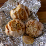three bulbs of roasted garlic on foil