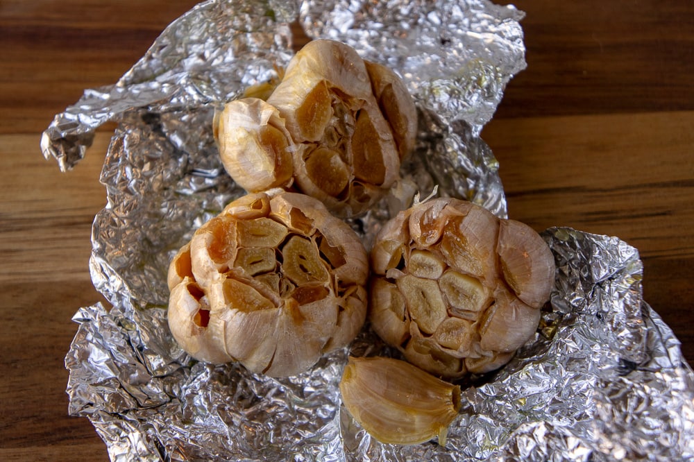 three bulbs of roasted garlic on foil