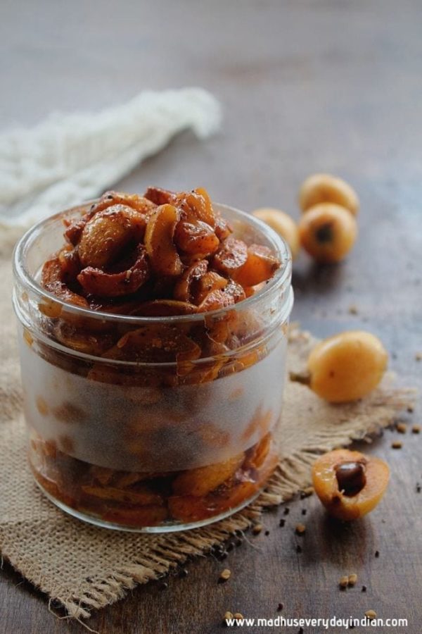 loquat pickle in a jar with fresh loquats around it from Madhu's Everyday Indian