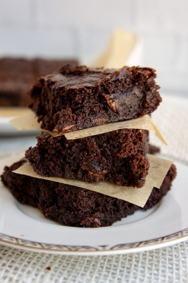 a stack of three olive oil brownies on a white plate