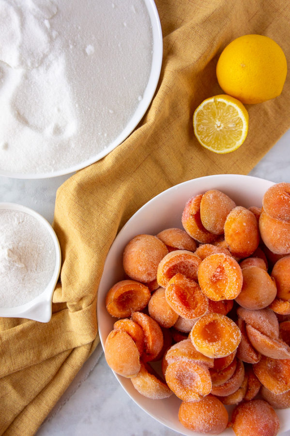 frozen apricots, lemons, sugar, and pectin with a yellow linen