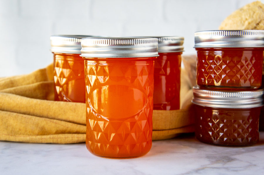 jars of apricot jelly on a white table