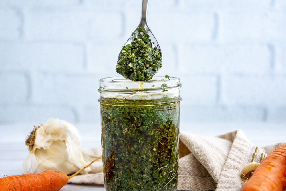 a jar and a spoon of chimichurri