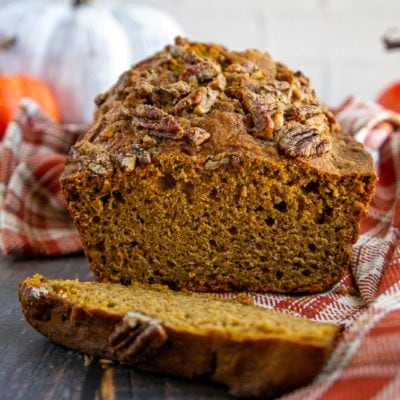 a healthy pumpkin bread loaf sliced on a wooden table