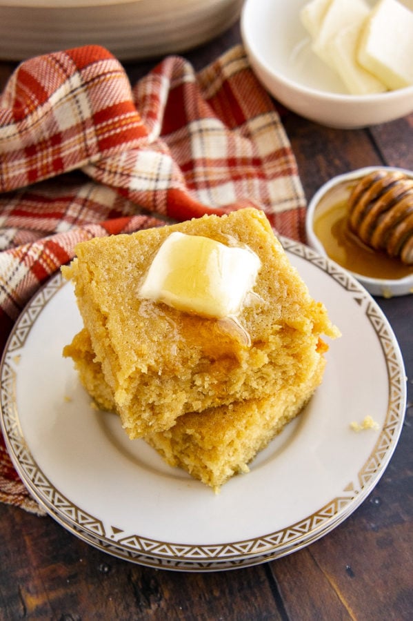 A stack of sweet cornbread with honey and butter