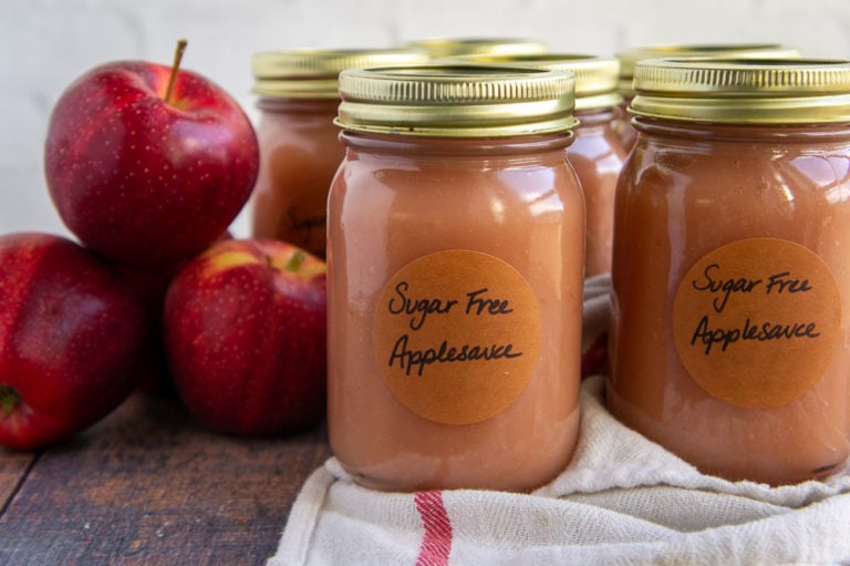 jars of applesauce with red apples