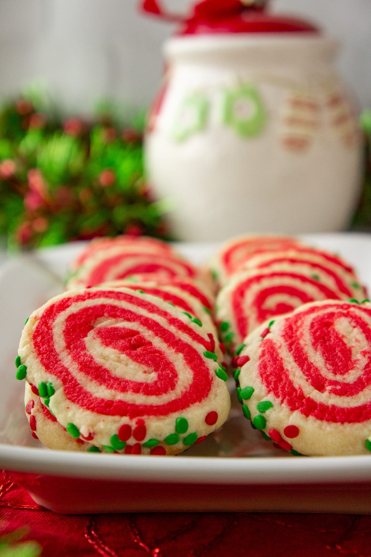 a plate of sugar cookies with red and white swirls.