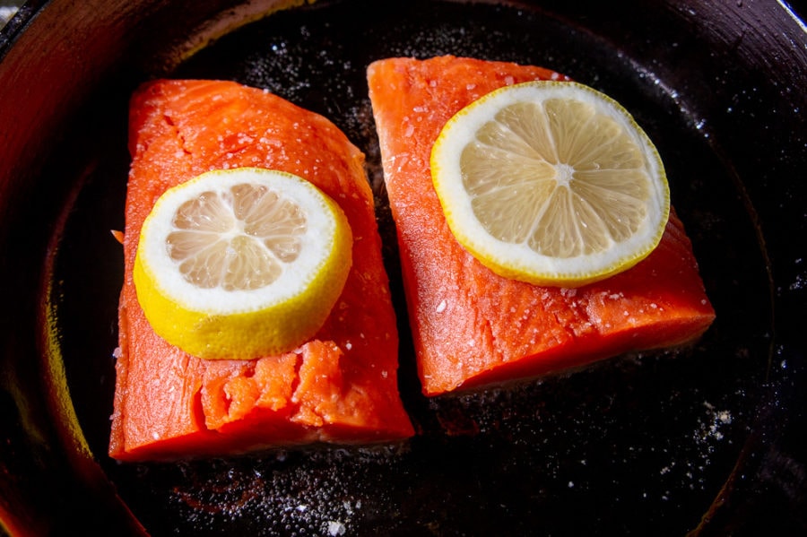 two salmon filets in a cast iron pan