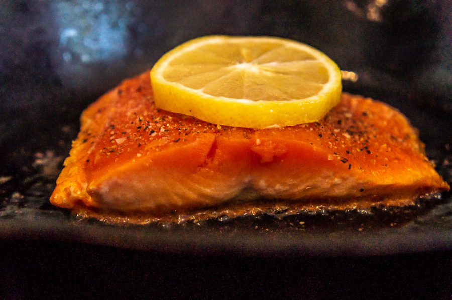 salmon cooking in a cast iron pan