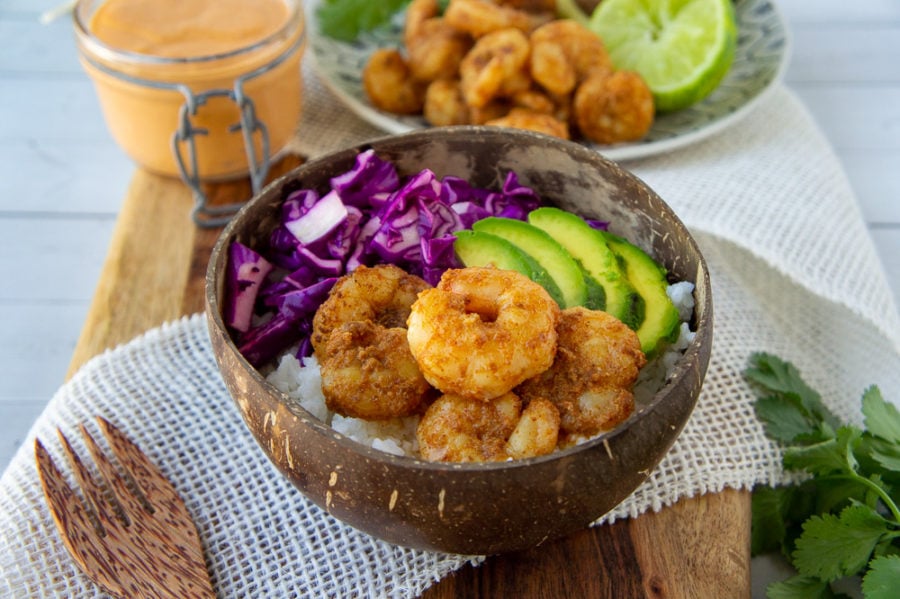 a bowl of rice, shrimp, avocado, and slaw