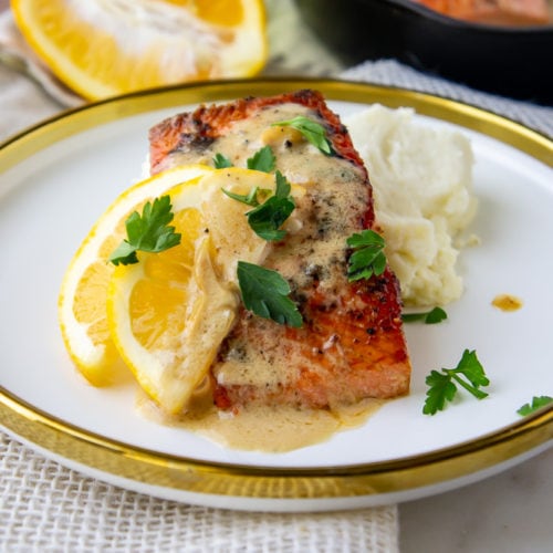 a plate of pan seared salmon with creamy lemon sauce