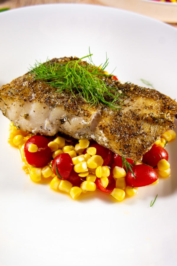 cod cooked with a dill and flaxseed crust on corn and tomatoes