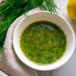 a bowl of lemon dill vinaigrette on a white table