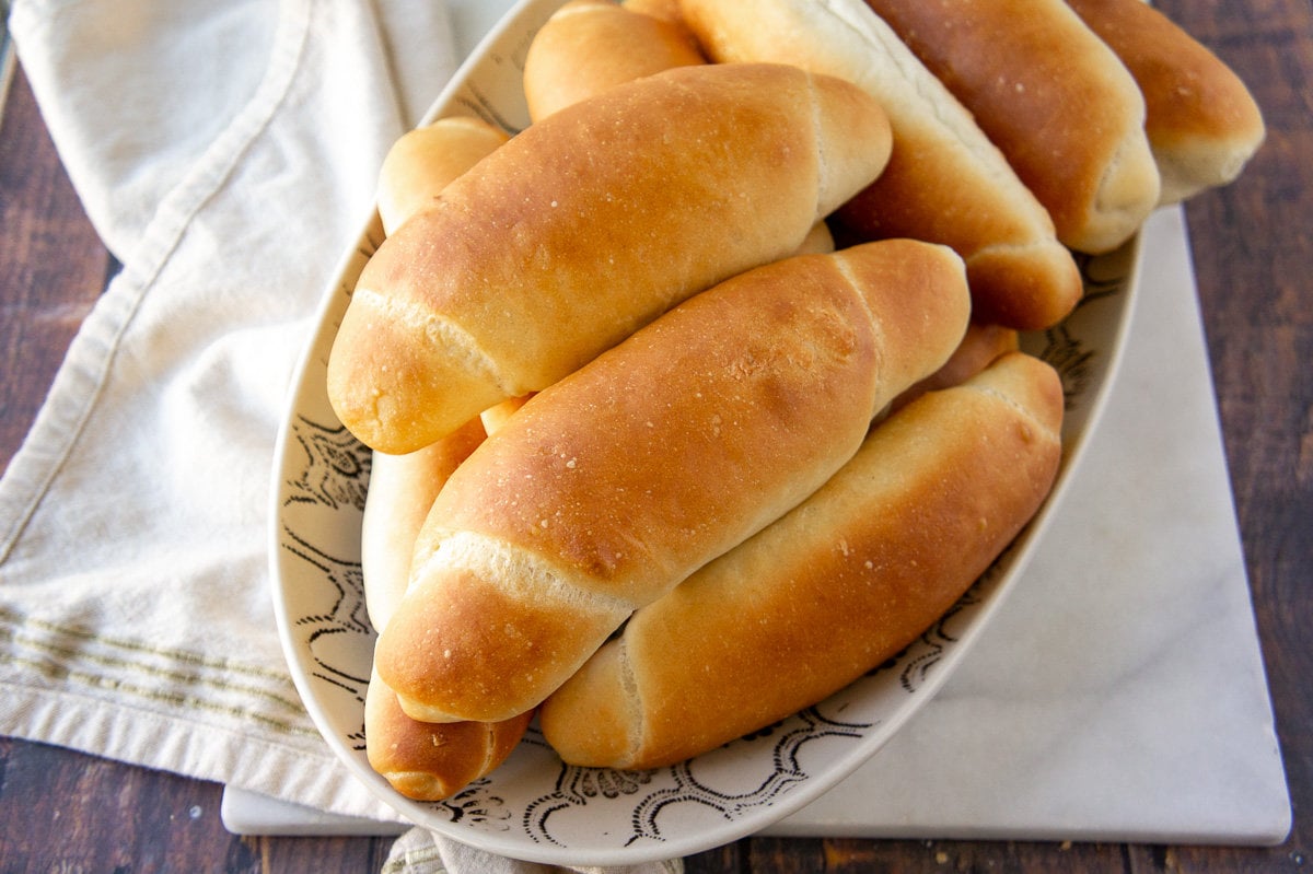 a bowl of homemade hot dog buns on a towel