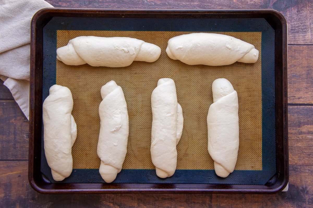 homemade hot dog buns, shaped on a baking sheet