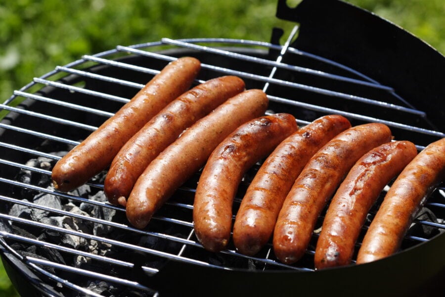 hot dogs on a grill.