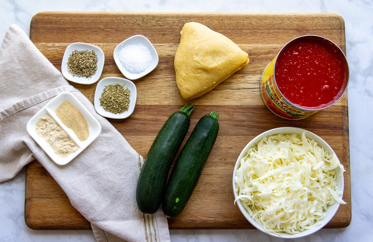 ingredients to make zucchini lasagna with noodles including spices, tomato sauce, and cheese.