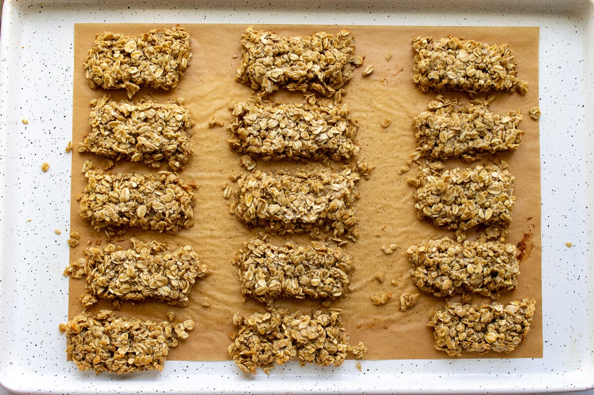 nut free granola bars cut into bar shapes on a parchment lined baking sheet.