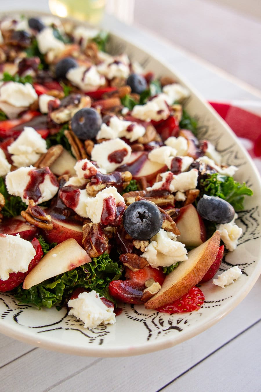 kale salad with berries, peaches, and cheese.